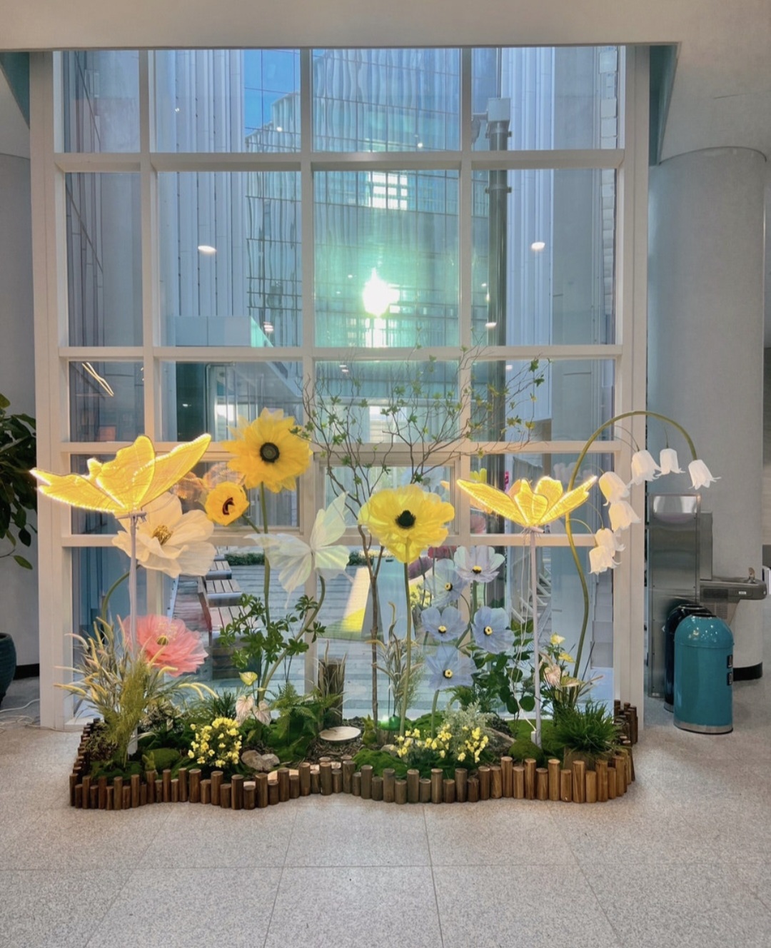 Giant flower sculptures integrated with indoor landscaping plants